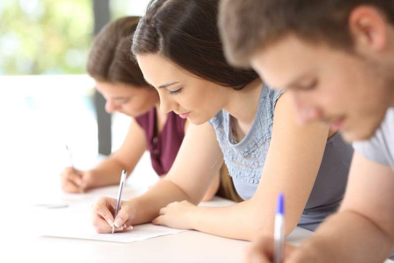 3 young students taking an exam