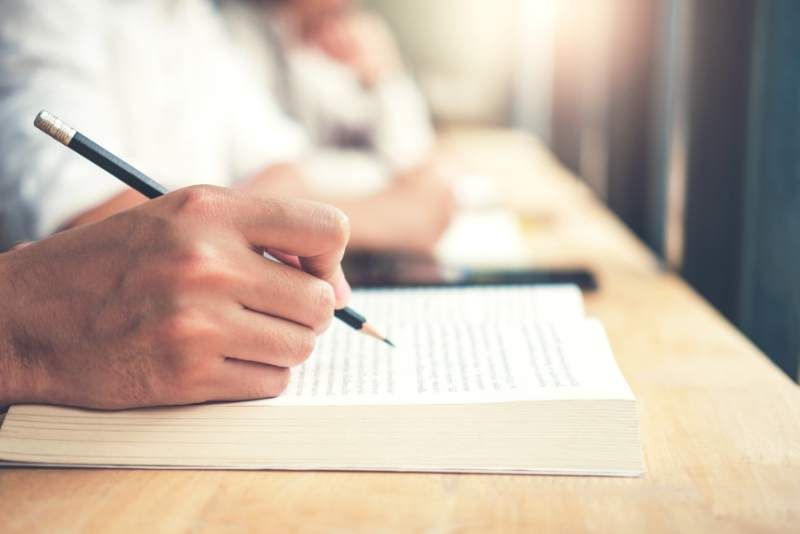 Closeup of hand holding pencil taking notes